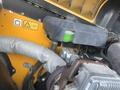 A close-up of the engine compartment of a 2013 JCB 510-56 Loadall showing various mechanical components and a green fluid reservoir
