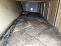 Interior of a 2013 Outdoor Wind River camper showing tiled floor with some visible pipes and a flat surface beneath furniture
