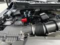 A 2024 Ford F-550 engine compartment featuring the engine block battery and air intake system with various electrical components visible
