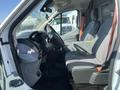 Interior view of a 2016 Ford Transit van showing the driver's seat dashboard and passenger seat with grey fabric upholstery