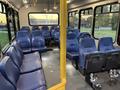 Interior of a 2019 Chevrolet Express bus featuring multiple blue seats arranged in rows with space for passengers and handrails for support