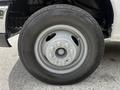 Close-up of a 2018 Ford Econoline wheel showing a silver alloy rim with six lug nut bolts and a dark textured tire tread