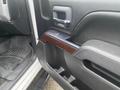 The interior door panel of a 2015 GMC Sierra 1500 featuring a wood grain accent and control buttons for windows and locks