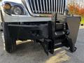 A 2011 International 7500 truck with a black front bumper and an attached plow mount system visible in the foreground