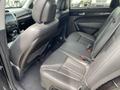Interior view of a 2015 Kia Sorento showing the backseat with two rows of seats in black leather and a central armrest between them