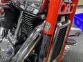 Close-up of a 2024 Harley Davidson Fat Boy showcasing chrome details and engine components with a vibrant red frame