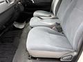 Interior view of a 2009 Toyota Hiace showing front seats with gray fabric upholstery and seatbelts without any passengers