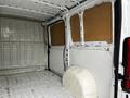 Interior view of a 2018 RAM Promaster van showing empty cargo space with metal walls and a white wheel well on the floor