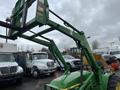 A 2003 John Deere 790 tractor with a front loader attachment in green color showcasing its hydraulic lift system