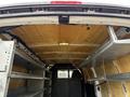 Interior view of a 2014 GMC Savana cargo van showing shelving on both sides and insulation material on the roof