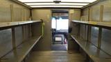 Interior of a 2011 Ford Econoline with metal shelves on either side and a driver's seat visible at the front