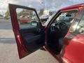 A 2015 Fiat 500L with an open driver's side door showing the interior and steering wheel