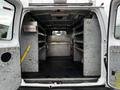 Interior view of a 2011 Ford Econoline van showing shelves and a first aid kit mounted on the wall