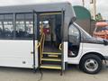 A 2018 Chevrolet Express bus with an open door revealing a seating area and steps leading inside