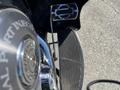 Close-up of a chrome footpeg on a 2004 Harley-Davidson FLHTCUI with a black rubber grip and detailed logo design on the footpeg surface