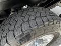 Close-up of a rugged tire with deep treads mounted on a chrome wheel, designed for off-road performance and durability on a 2020 Ford F-350 Super Duty