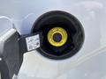 Close-up of the fuel cap on a 2016 Ford F-150 with a yellow easy fuel label and a fuel nozzle inserted into the opening