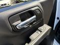 The interior door panel of a 2022 GMC Sierra 1500 features a chrome handle and controls for windows and locks in a black leather finish
