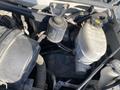 View of the engine compartment of a 2012 GMC Savana showing various components including an oil filter and a coolant reservoir