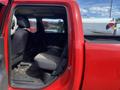 Interior view of a 2012 RAM 2500 truck showing the rear seating area with gray fabric seats and a red exterior visible from the open door