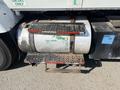 A 2007 International 7300 features a large metal fuel tank with corrosion marks and two metal steps for access located beside the tank