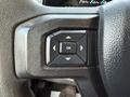 Close-up of the steering wheel controls of a 2018 Ford F-350 featuring an OK button and directional arrows for navigation functions