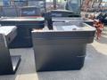 Two retail checkout counters in black with a flat surface and a curved edge, featuring a receptacle for cash and a space for a bagging area