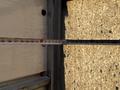 A measuring tape is extended along the edge of a surface showing measurements in inches and centimeters