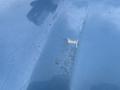Close-up of a scratched and chipped blue hood of a 2010 Ford Econoline