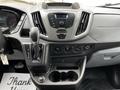 Dashboard of a 2017 Ford Transit 350 featuring a gear shift, audio controls, climate settings, and cup holders