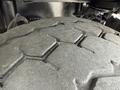Close-up of a worn tire from a 1998 Freightliner FL80 showcasing deep treads and rugged texture