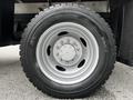 Close-up of a Michelin tire mounted on a silver wheel designed for a 2011 Ford F-550 featuring a thick tread pattern and distinct grooves