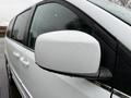 A 2017 Dodge Grand Caravan with a white exterior featuring raindrops on the side mirror and a sleek design