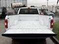 A white 2018 Ford F-150 truck with an open bed showcasing the interior space and metal sides of the cargo area