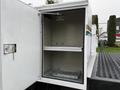 A 2001 Ford F-350 with an open storage compartment revealing empty shelves inside