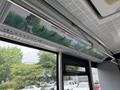 Interior view of a 2018 Grande West Vicinity bus showcasing green travel advertisements on overhead screens