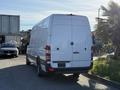 A white 2016 Mercedes-Benz Sprinter van parked with its back facing the viewer showcasing its sleek design and distinctive rear lights