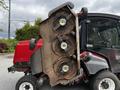 A 2012 Toro Groundsmaster with a raised mower deck featuring three circular blades and visible wear on the metal surface