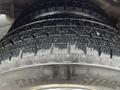 Close-up of a Bridgestone tire with deep tread patterns mounted on a 2016 Chevrolet Express