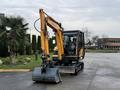 A yellow and black 2022 Hyundai R55-9A compact excavator with a front bucket attachment and a cab for the operator