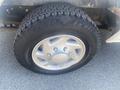 The image shows a close-up of a tire on a 2009 Ford Econoline with a silver wheel and a tread pattern indicating it is suitable for road use