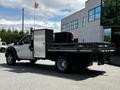 A 2016 Ford F-550 with a flatbed design featuring a tool box on the rear and a mounted tail light system