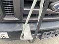 A 2010 Ford Econoline van with a metal grille and a front bumper featuring a mounting bracket and visible wear marks