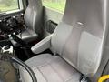 Interior view of a 2016 International 7400 truck featuring two grey cloth seats with armrests and controls for operating equipment on the dashboard