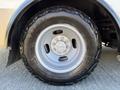 Close-up of a wheel from a 2017 Chevrolet Express featuring a silver rim and a rugged black tire with the name Outpost Tires visible on the sidewall