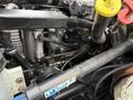 A close-up view of the engine of a 2016 International CE300 featuring various metallic components and hoses with some fluid lines and caps visible