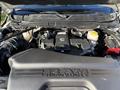 A 2023 RAM 3500 engine with a large black cover displaying the RAM logo and various components including hoses and fluid reservoirs visible