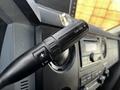 Close-up of the transmission control lever in a 2011 Ford F-450 SD featuring buttons for gear shifting and a textured grip