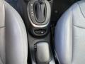 Close-up of the gear shift area in a 2015 Fiat 500L featuring the gear selector and adjacent controls in a car interior