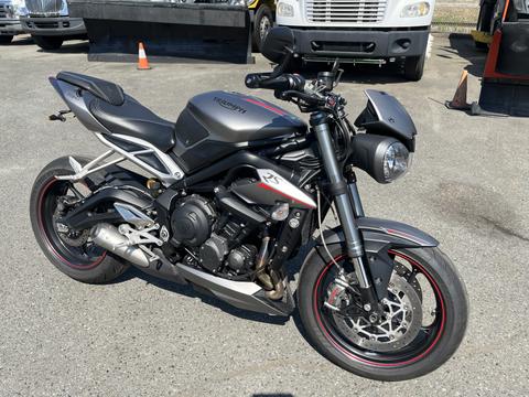 A 2018 Triumph Street Triple RS motorcycle in black and silver with red accents displayed prominently in the foreground